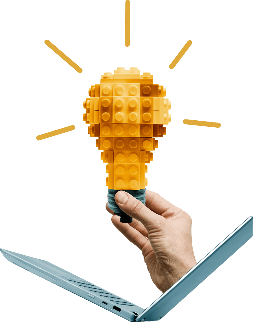 custom rag development, hand holding a lego brick lightbulb over a laptop